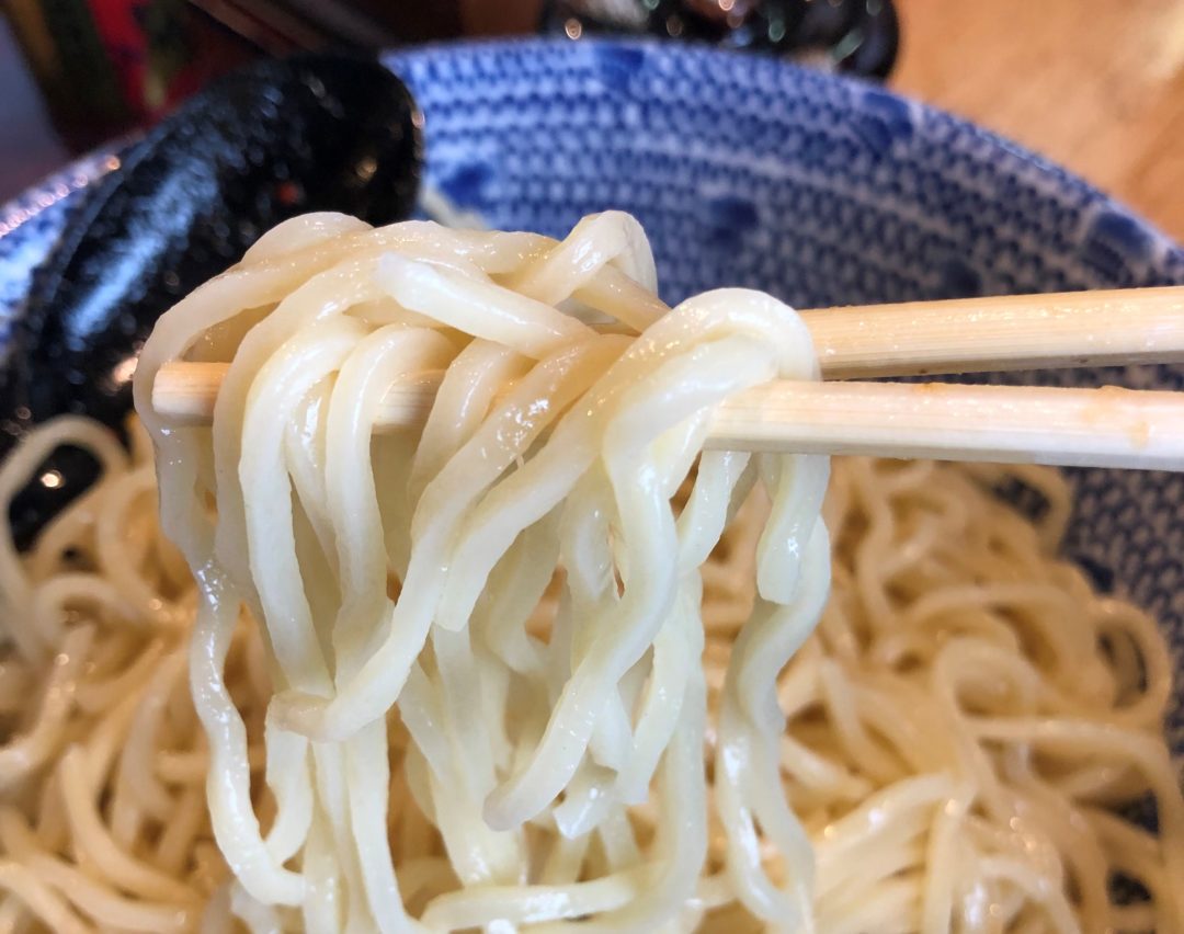 箸で持ったラーメンの麺
