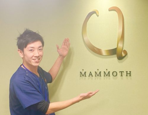 マンモス脱毛の代表がマンモス脱毛のロゴを手を広げて指している様子