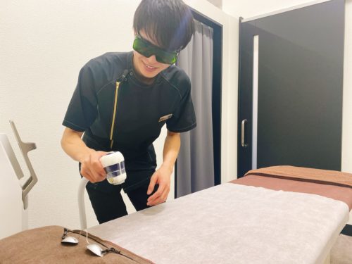 男性看護師が照射器を持って施術する姿